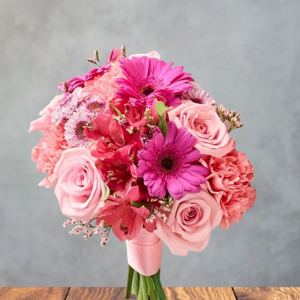 Pink bouquet of roses, gerbera daisies, and carnations on a stand