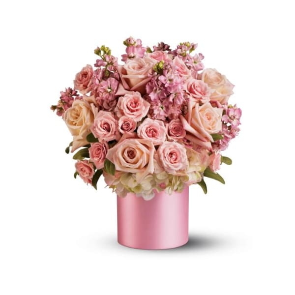 Pink and peach roses arranged in a pink cylindrical vase