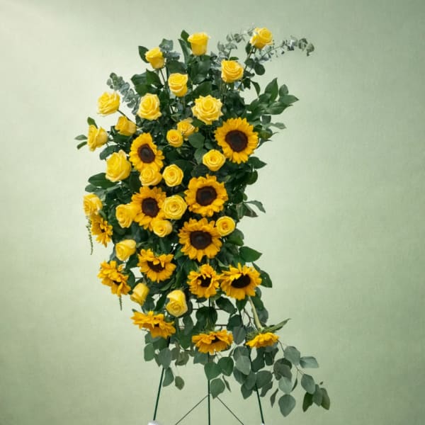 Tall arrangement of yellow roses and sunflowers on a stand