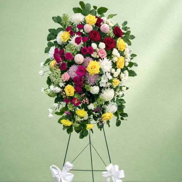 Standing floral spray with roses and chrysanthemums on an easel