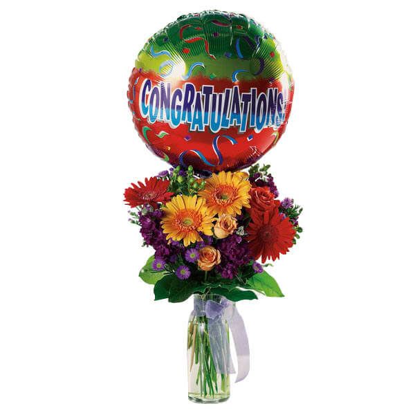 Bouquet in a glass vase with a congratulations balloon above it