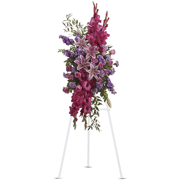 Tall standing floral spray with pink lilies and purple flowers on an easel