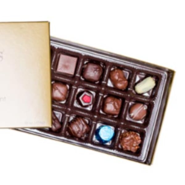 Gold-lidded box of assorted milk and dark chocolates with two open trays.