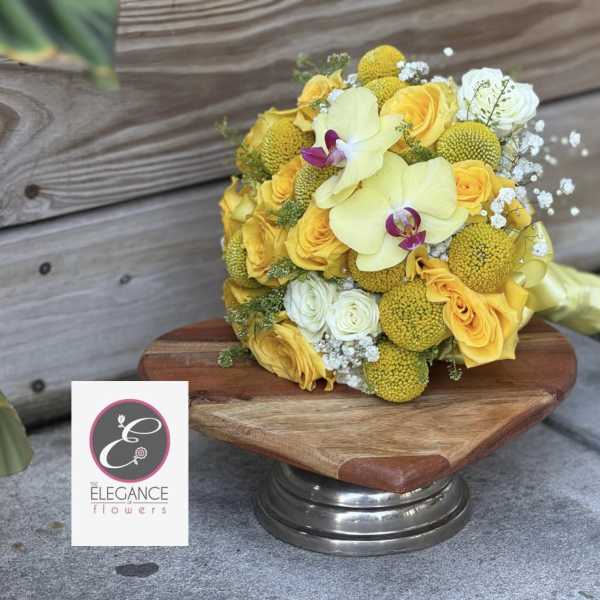 Hand-tied bouquet of yellow roses and pale orchids resting on a wooden pedestal.