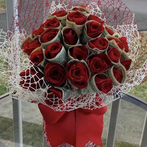 Red roses wrapped in 20 bills in a clear vase by lav.ishbouquets