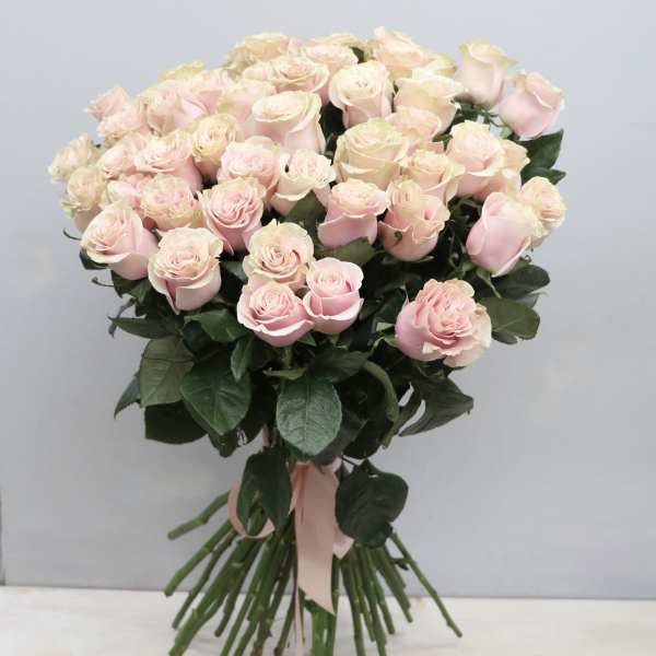 Large hand-tied bouquet of pale pink roses with long stems and a pink ribbon