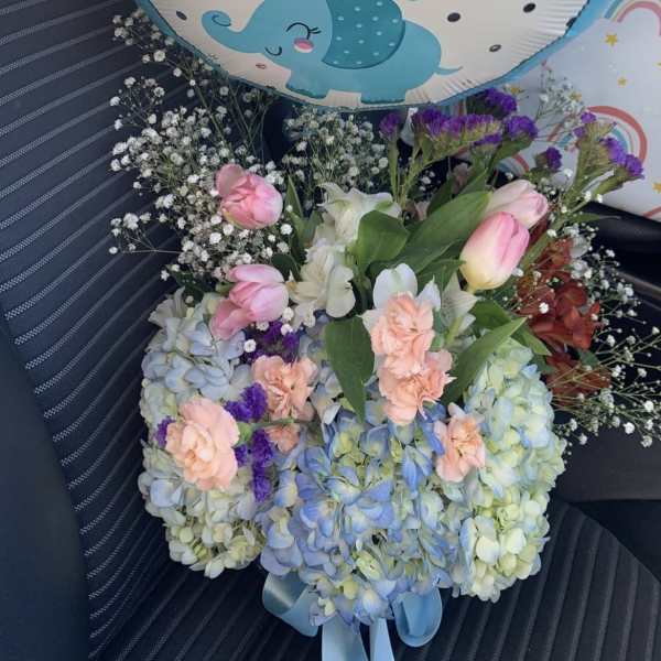 Hydrangeas and roses in a clear vase by lav.ishbouquets