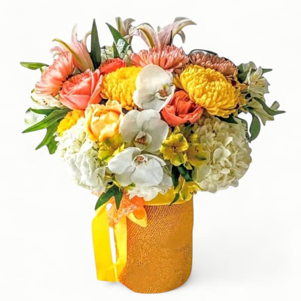 Bright mixed bouquet of yellow, white and peach flowers in a yellow textured vase with ribbon handle