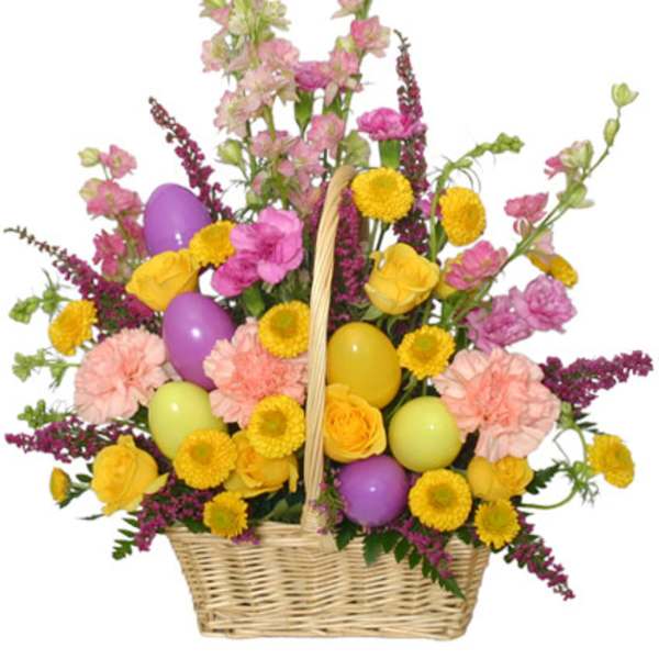 Basket arrangement with yellow roses, pink carnations, snapdragons, and colorful Easter eggs.