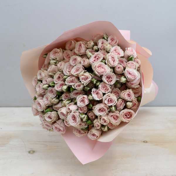 Large bouquet of pale pink spray roses wrapped in soft pink paper