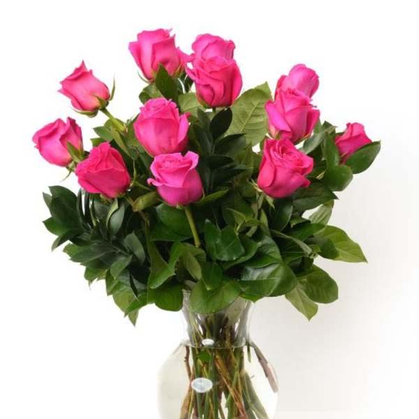 Arrangement of bright pink roses in a clear glass vase with water
