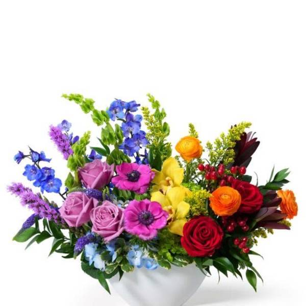 Colorful low flower arrangement in a white bowl-shaped vase