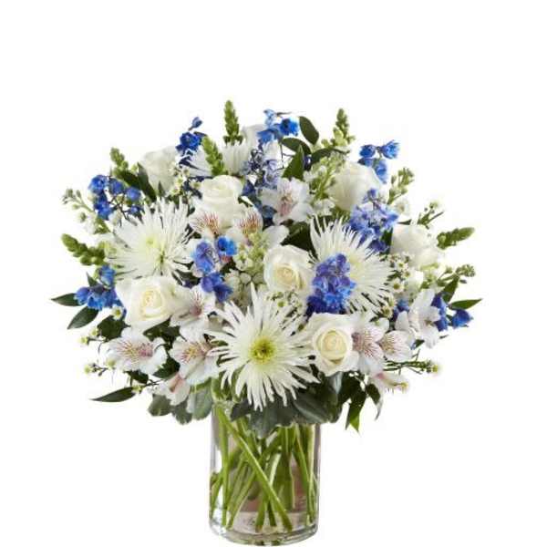 White and blue mixed flower arrangement in a clear glass cylinder vase