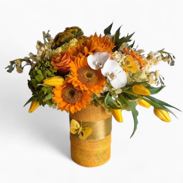 Bright arrangement of orange sunflowers, white orchids, and yellow tulips in a wrapped yellow vase