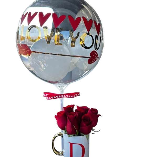 Red roses in a white D-initial mug with an 'I love you' heart balloon attached.