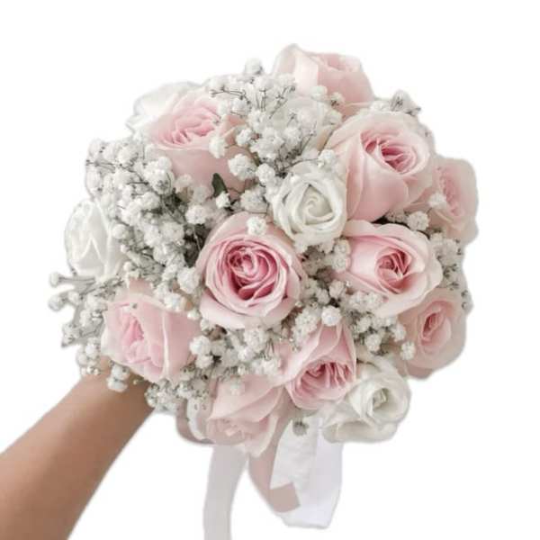Round bouquet of pale pink and white roses with baby's breath, held in one hand