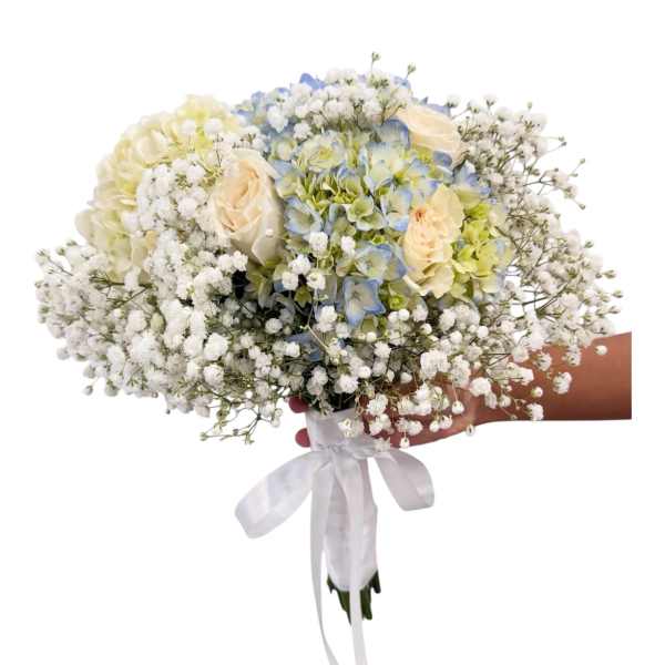 Wedding hand-tied bouquet with white baby's breath, cream roses, and blue hydrangeas wrapped in white ribbon.