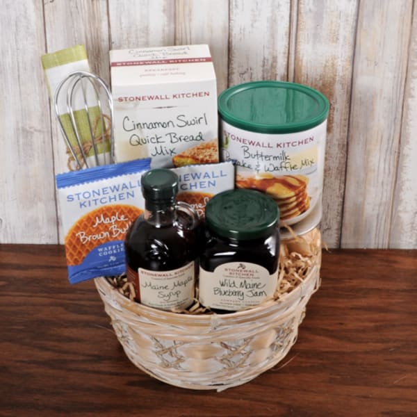 Breakfast-themed gift basket with baking mixes, maple syrup, jam, and a whisk