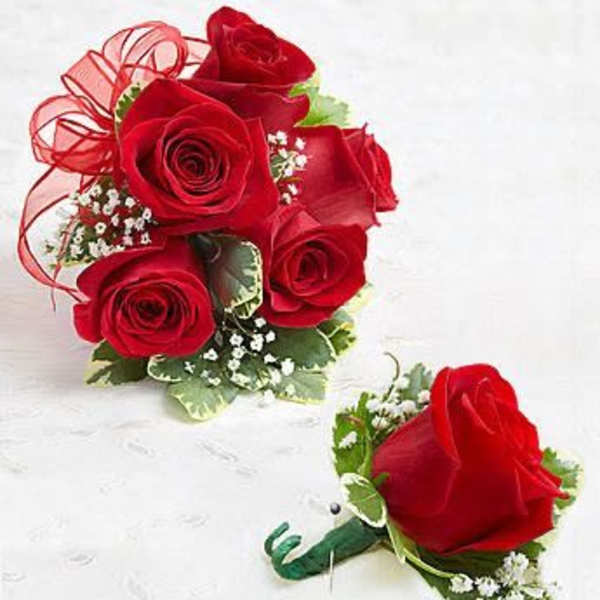 Red rose posy bouquet with matching single-rose boutonniere on a white surface
