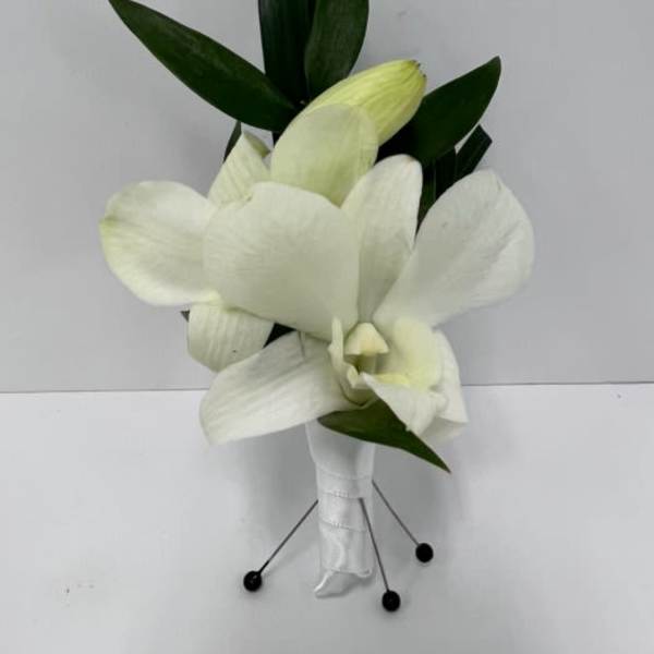 White cymbidium orchid boutonniere with wrapped stem and greenery backing