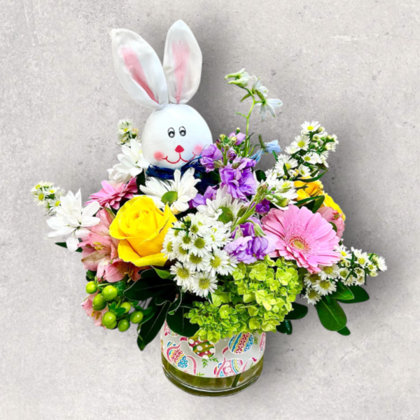 Easter bunny pick in a pastel mixed flower arrangement with yellow rose and pink gerbera in a glass vase.