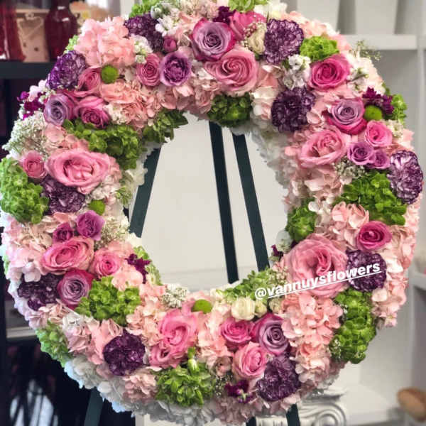 Large wreath of pink and purple roses and hydrangeas on a stand