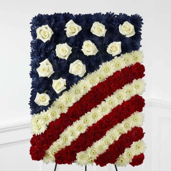 Standing floral spray shaped like an American flag with red, white, and blue flowers