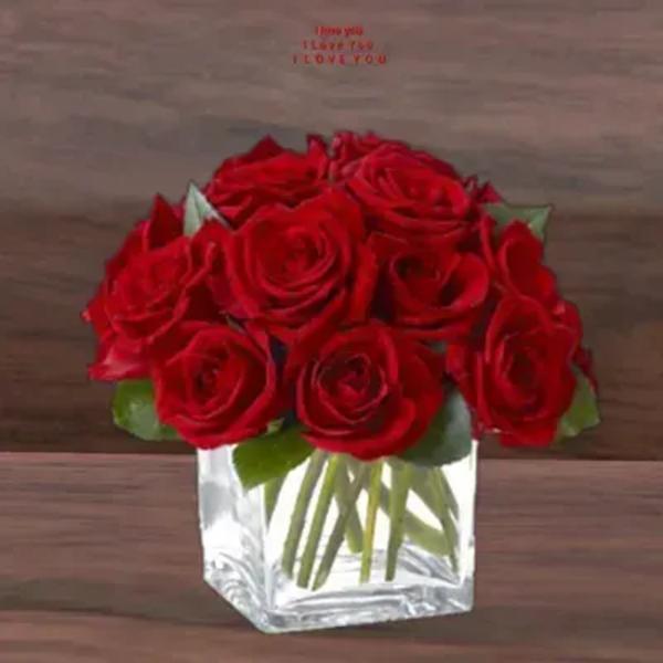 Compact bouquet of red roses in a clear glass cube vase