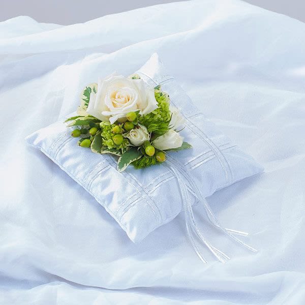 White rose and green berry floral accent on a small white satin ring pillow