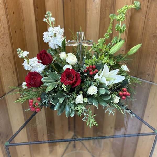Red and white floral arrangement with a glass cross in the center