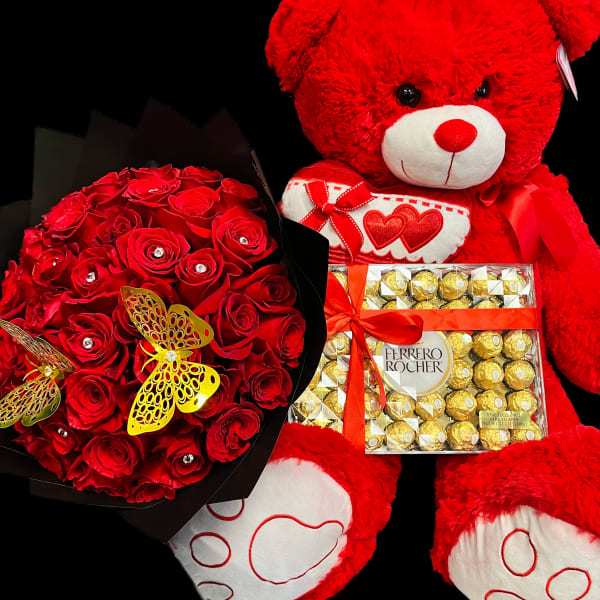 Red rose bouquet with large red teddy bear and Ferrero Rocher chocolates on a black background