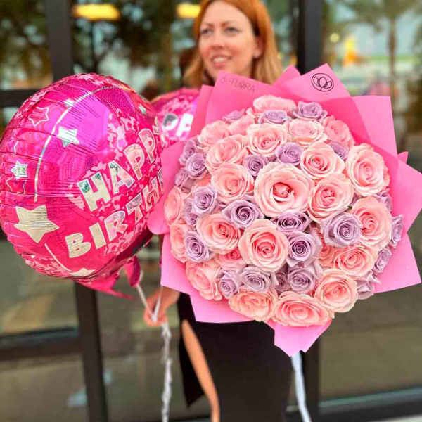 Pink and lavender rose bouquet wrapped in pink paper with pink Happy Birthday balloons