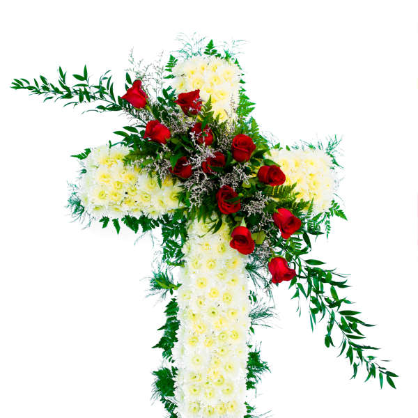 White floral cross with red roses arranged diagonally across the center
