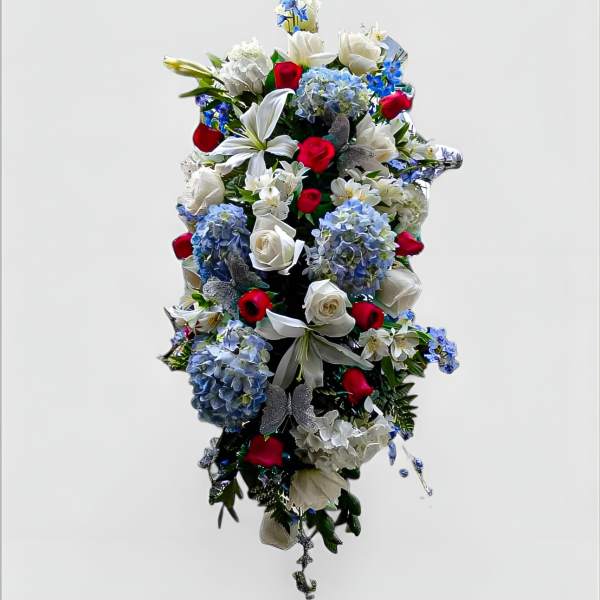 Red, white, and blue standing spray with lilies, roses, and hydrangeas in a cascading vertical design