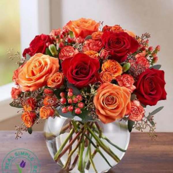 Bouquet of red and orange roses in a clear glass vase