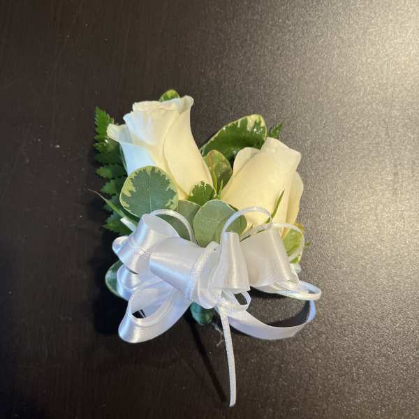 Two white rose blooms with a white ribbon bow