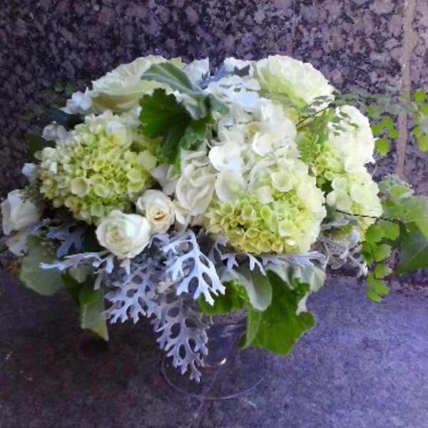 White and pale green floral arrangement in a clear vase
