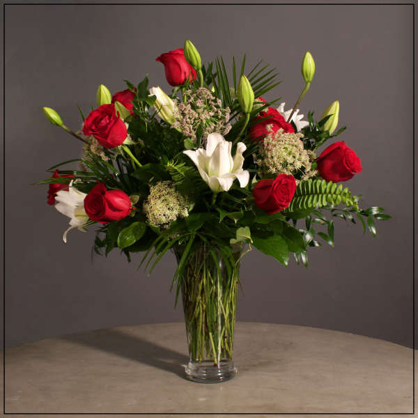 Red roses and white lilies in a clear glass vase