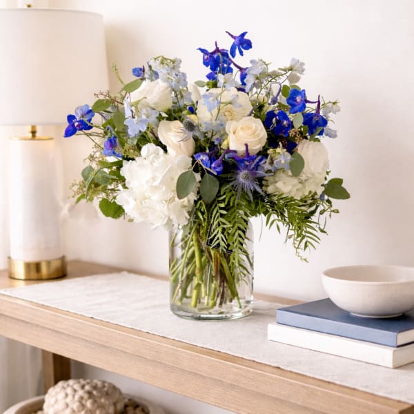 Blue and white flower arrangement in a clear glass vase