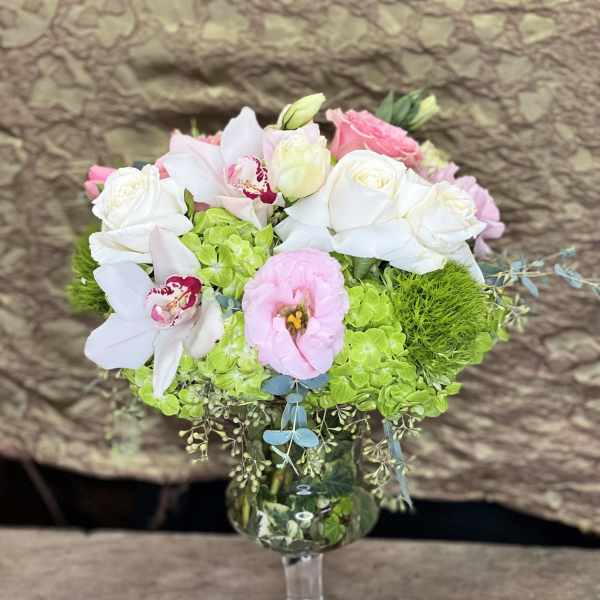 Bouquet of white and pink flowers in a clear stemmed vase