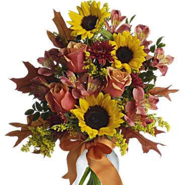 Bouquet of sunflowers, roses, and pink alstroemeria in a glass vase