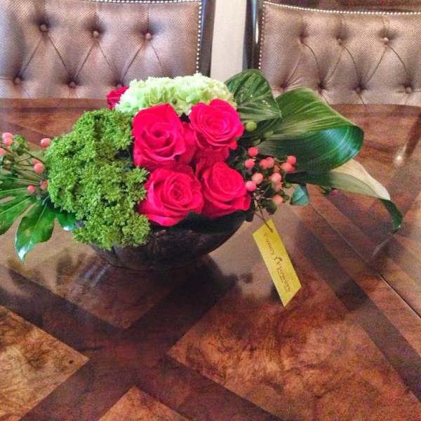 Pink roses and green hydrangea in a low black bowl centerpiece