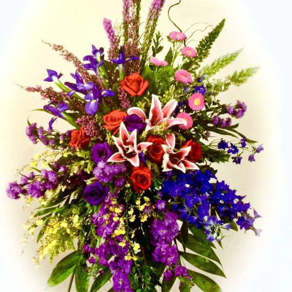 Tall mixed bouquet with red roses, pink lilies, and purple flowers
