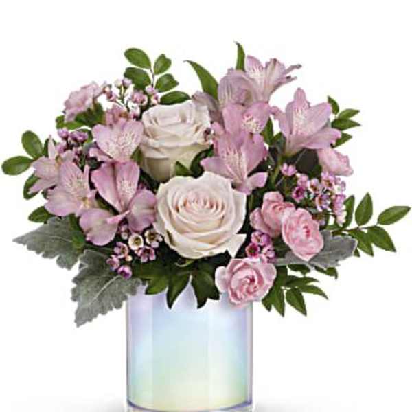 Pink and white flowers arranged in an iridescent glass vase
