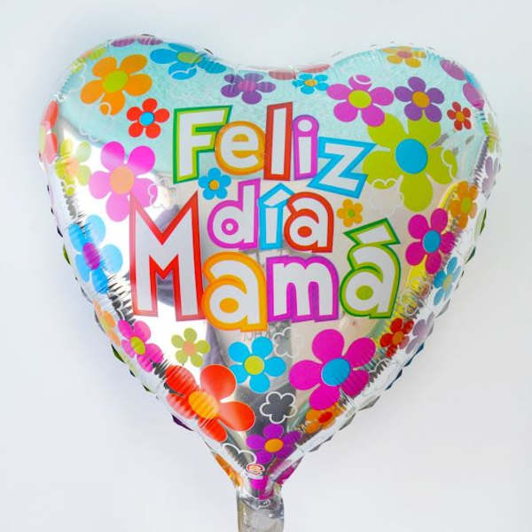 Heart-shaped silver balloon with colorful flowers and the Spanish phrase “Feliz día Mamá”.