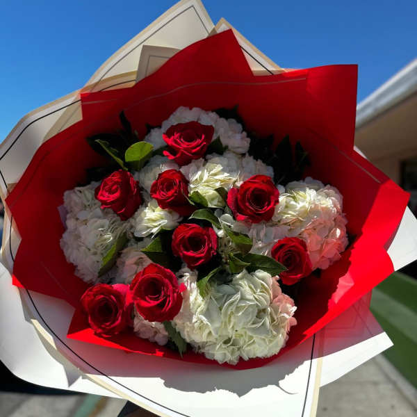 Bouquet of red roses and white hydrangeas wrapped in red and white paper