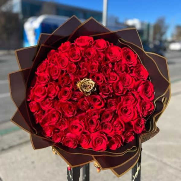 Large bouquet of red roses wrapped in dark paper