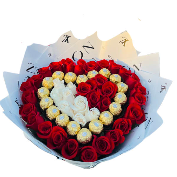 Round box of red and white roses arranged with gold-wrapped chocolates in a heart pattern