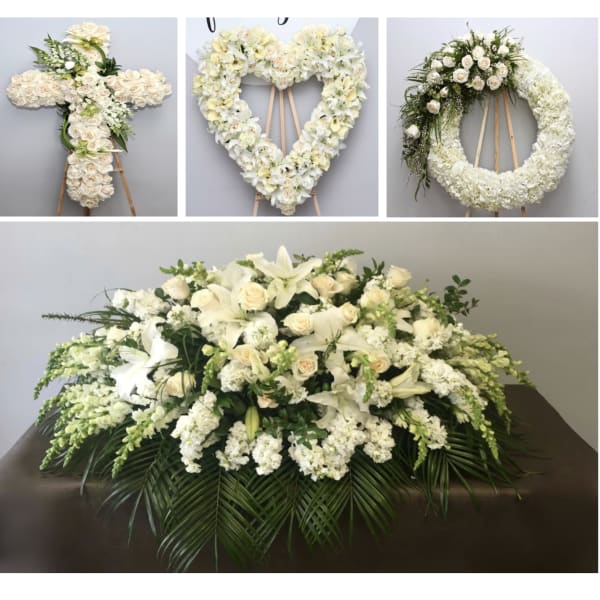 White floral funeral tributes on stands and a large casket spray