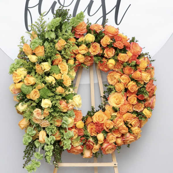 Large orange and yellow rose wreath on an easel